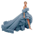 A flowing off-the-shoulder blue tulle luxury women’s fashion high low gown with layered ruffles and dramatic train