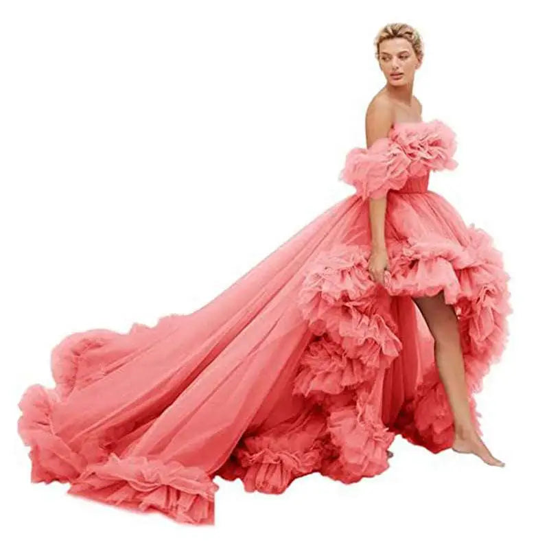 A voluminous coral pink tulle luxury women’s fashion high low gown with layered ruffles and off the shoulder design