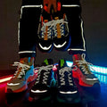 A pair of black orange mesh fashion casual running shoes with neon green accents and reflective glowing laces
