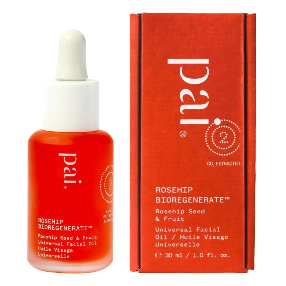 A vibrant red glass bottle of Pai organic rosehip bioregenerate universal facial oil with white dropper cap and matching orange-red packaging