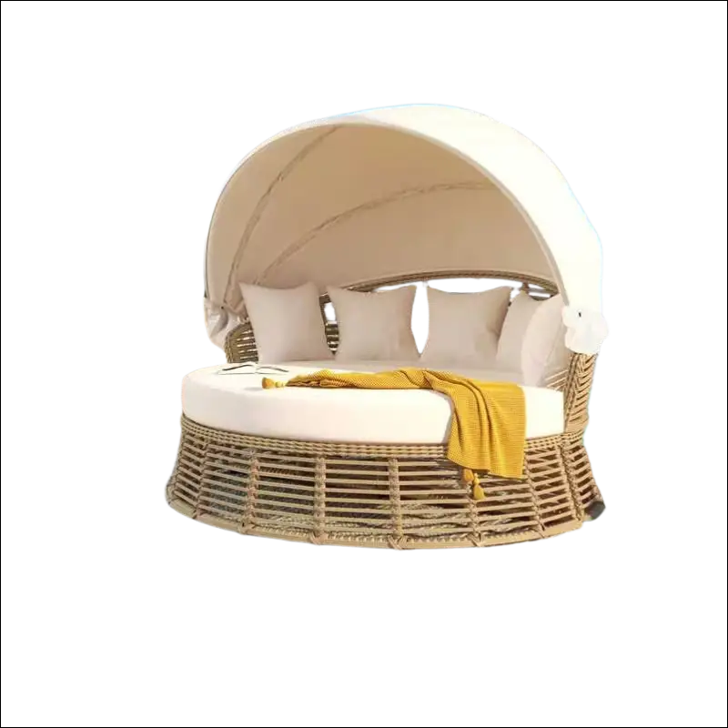 Beige outdoor patio rattan round daybed with canopy and white cushions accented by yellow throw blanket sofa bed style