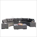 Curved outdoor wicker round sofa set with dark gray tufted cushions, woven wicker frame, and matching tables