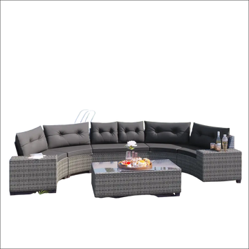 Curved outdoor wicker round sofa set with dark gray tufted cushions, woven wicker frame, and matching tables