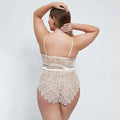 Beige oversized lace bodysuit with floral design and satin ribbon belt highlighting the waist detail