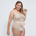 Beige oversized lace bodysuit featuring a delicate lace design and a satin ribbon belt tied at the waist