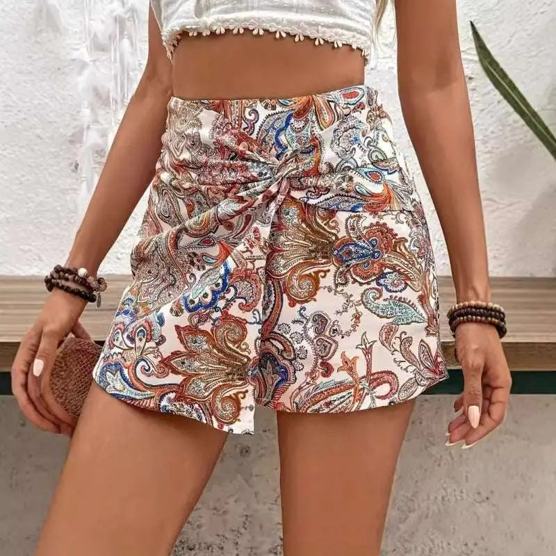 White high-waisted paisley print knot shorts featuring a tied waistband and waist fake two-piece skirt design