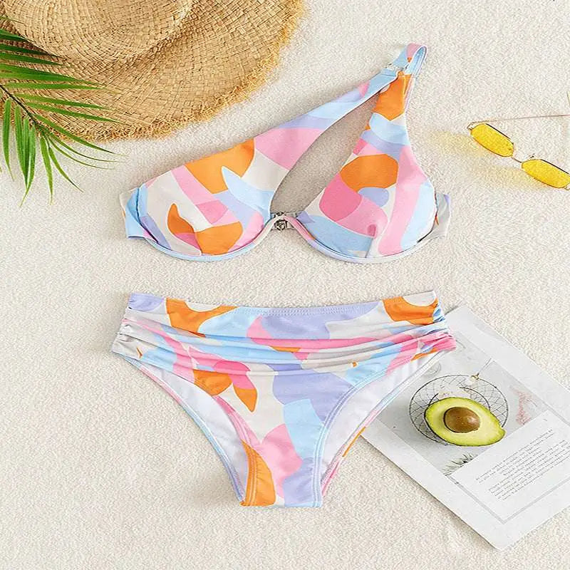 Pastel abstract bikini print fashion split swimsuit featuring a white base with orange pink and blue geometric patterns