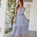 A flowing blue and white floral summer dress with ruffle cap sleeves and short flutter sleeves perfect for summer wear