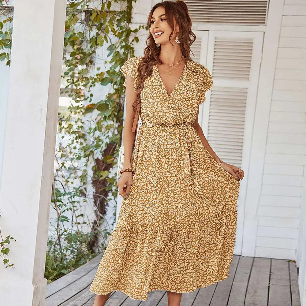 A flowing yellow floral summer dress with ruffle cap sleeves and a v-neckline perfect for warm weather wear
