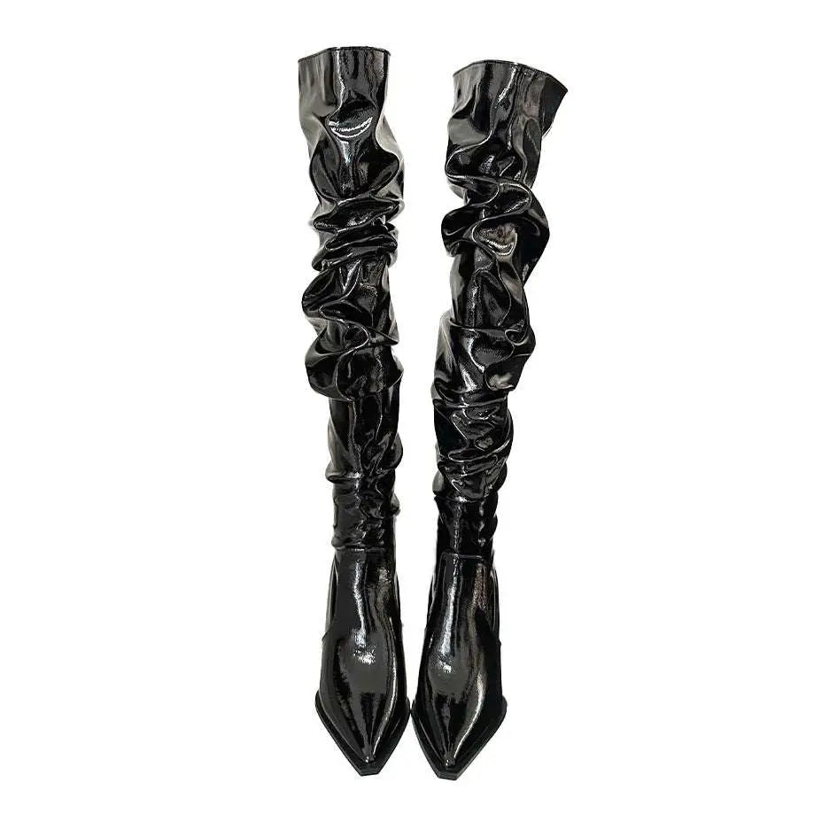 Black patent thigh high boots with ruched glossy texture and pointed toe featuring an autumn stiletto heel design