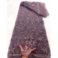 A delicate mauve peach ribbon flower beaded tulle lace fabric with intricate floral patterns and rhinestone embellishments