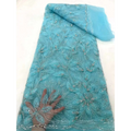 A delicate turquoise peach ribbon flower beaded tulle lace fabric with intricate floral patterns and silver beads