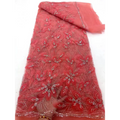 A vibrant coral-red peach ribbon flower beaded tulle lace fabric with intricate floral appliqués and silver beading