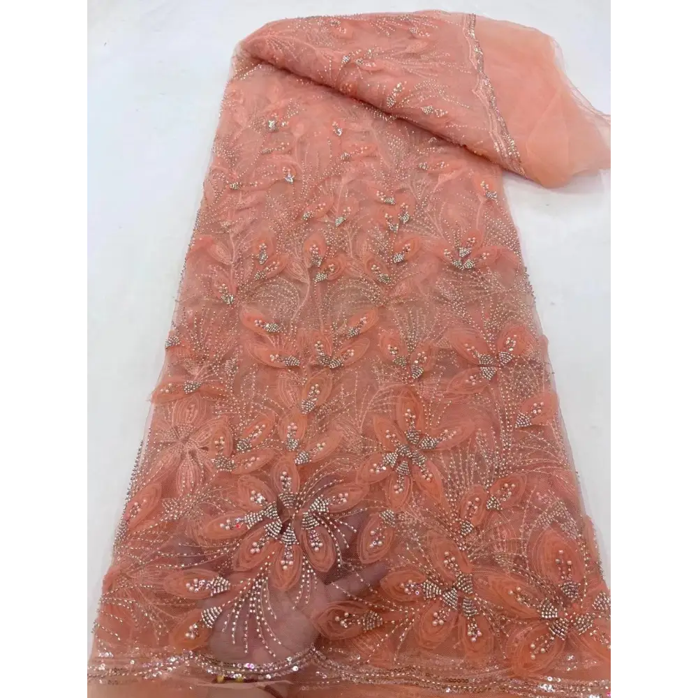 A delicate peach ribbon flower beaded tulle lace fabric with intricate floral embroidery and sparkling rhinestones