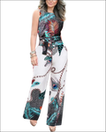 A vibrant sleeveless jumpsuit with bold teal black and red peacock feather print on white base fabric