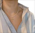 A delicate gold cross pendant necklace with small lustrous pearls perfect for luxury women’s fashion
