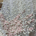 A luxury wedding veil in delicate white sheer fabric with varying sized pearl beaded accents for elegant bridal wear