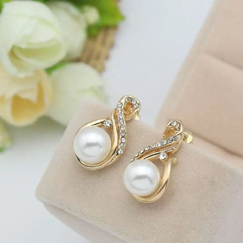 Gold-toned earrings set popular featuring swirling design with central white pearl and clear rhinestones for dinner bridal