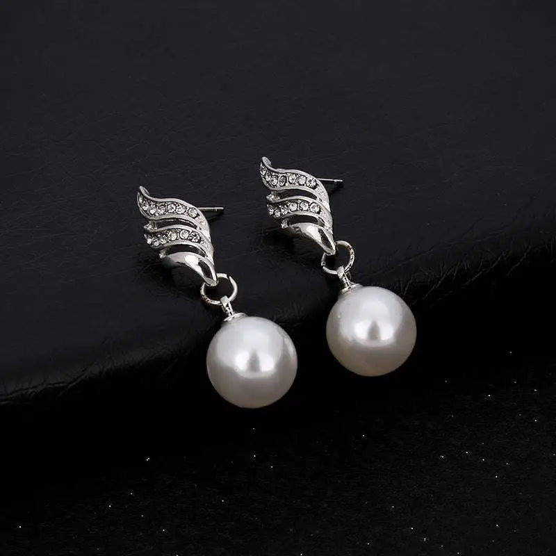 Silver wing-shaped earrings with clear rhinestones and white pearls complement pearl rhinestone necklace explosion models accessories sold on united states ebay