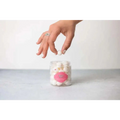 A clear glass jar with a pink label containing white spherical candies in personalized ashley pampering skincare mom gift