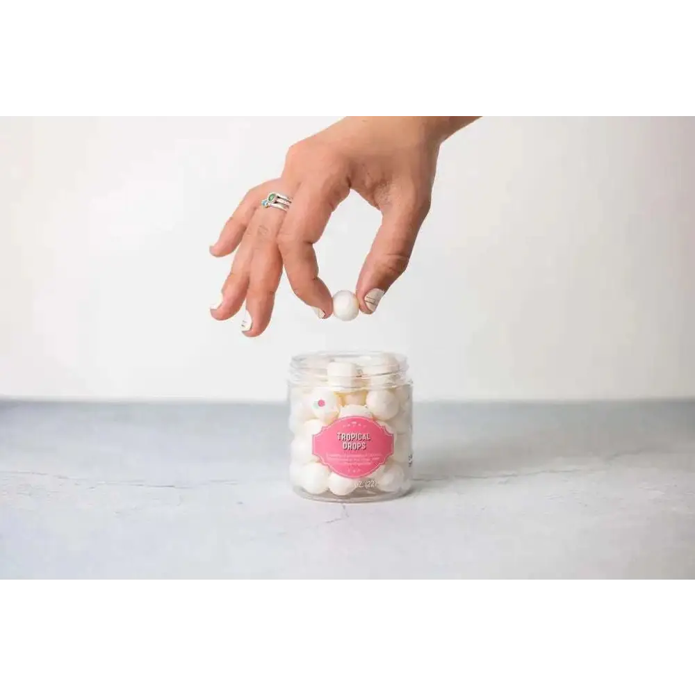 A clear glass jar with a pink label containing white spherical candies in personalized ashley pampering skincare mom gift