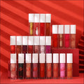 A collection of phoera high shine crystal lip glosses in clear tubes with white caps in shades from nude to deep red for luxury women’s fashion