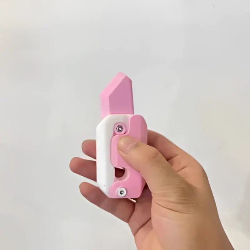 Pink and white plastic utility knife with a retractable blade for lime radish knife gravity cub toy use