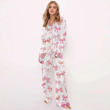 White printed long-sleeve pyjama suit with pink bow prints featuring a button-front top and wide-leg pants