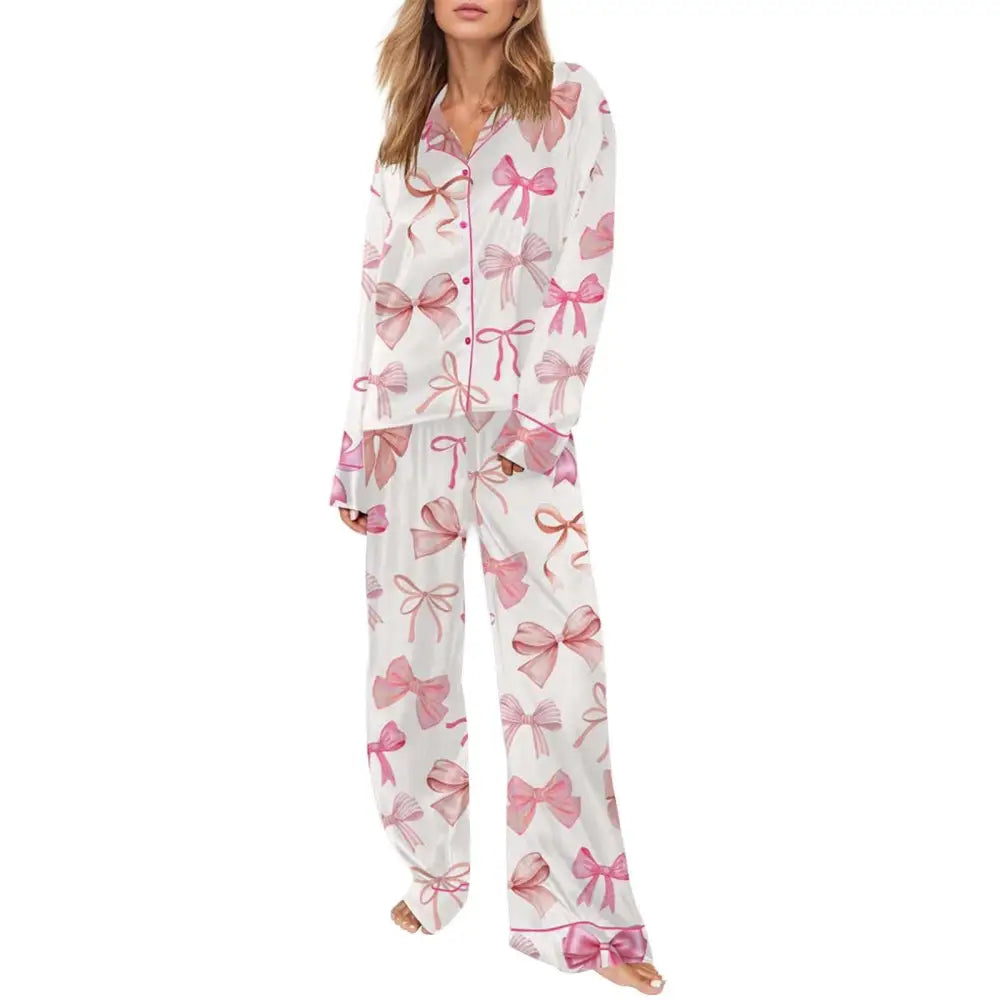 White pyjama suit with playful pink bow print featuring long sleeves button-front top and wide-leg pants