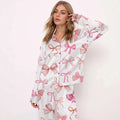 White printed long-sleeve pyjama suit with playful pink bow pattern in varying shades and sizes