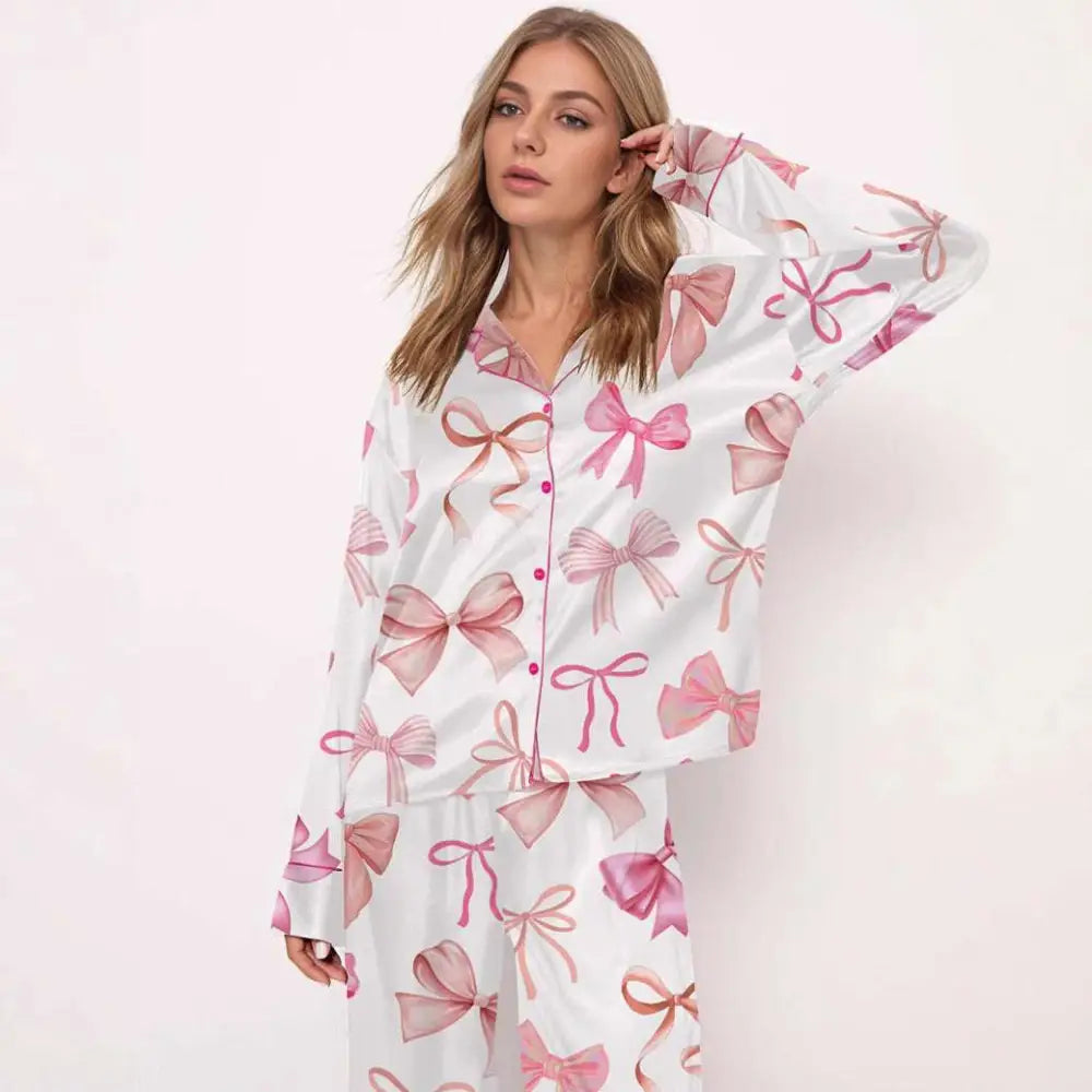 White printed long-sleeve pyjama suit with playful pink bow pattern in varying shades and sizes