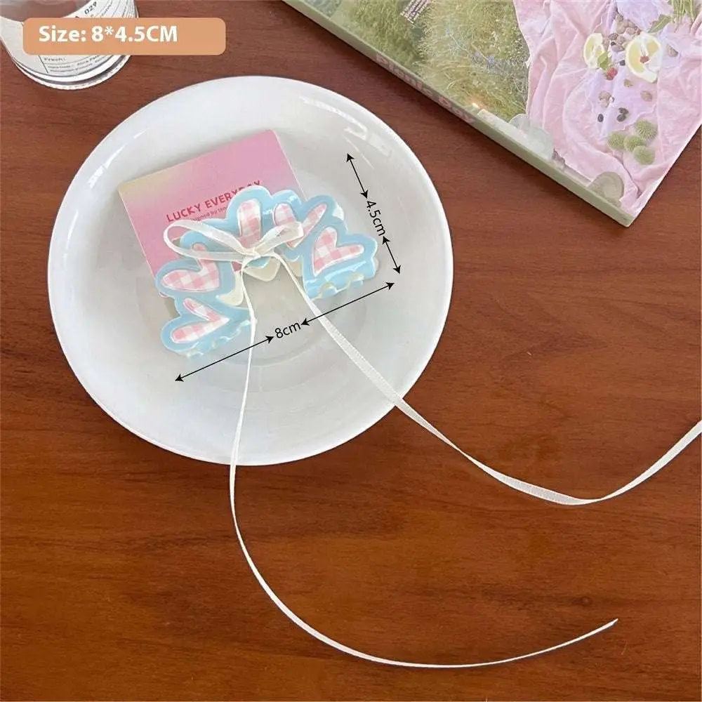 Pastel blue and pink heart-shaped resin charm with white ribbon on pink butterfly floral small secure jaw clip with bow
