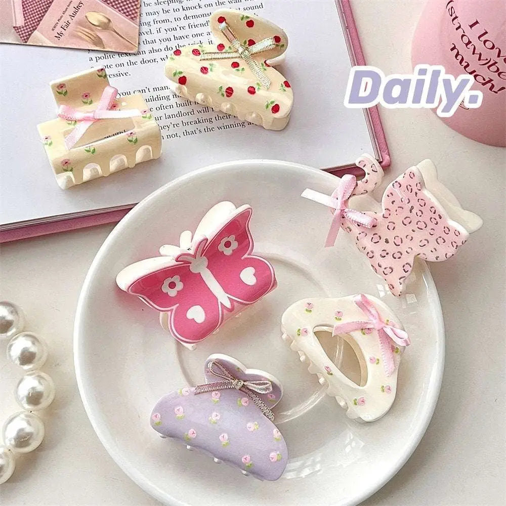 Pink butterfly floral small jaw clip with white floral details and a secure jaw clip design with a pink bow