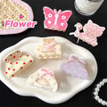 Pastel-colored pink butterfly floral small jaw clip made of plastic with bow accents for secure hold in hair