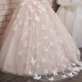 A delicate blush pink lace girls pengpeng skirt with butterfly appliqués on soft tulle fabric