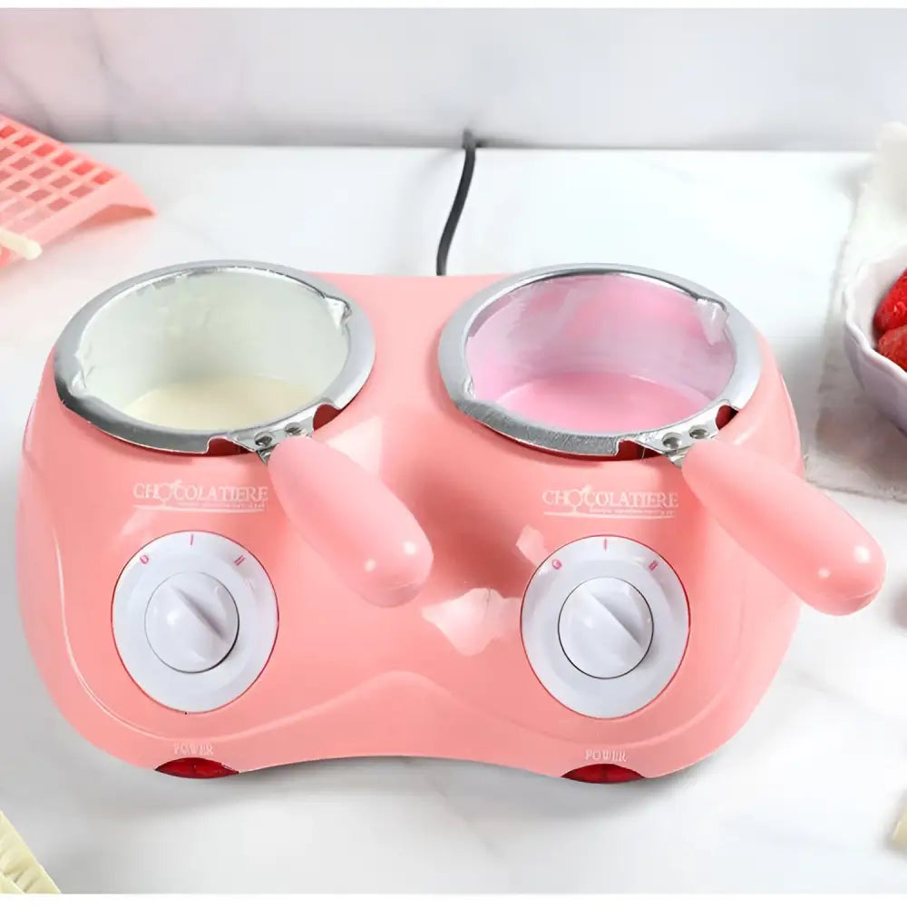 Pink dual chamber chocolate melting pot with silver-rimmed bowls and white control dials for chocolate melting furnace