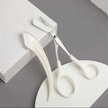 White plastic eyebrow trimmer with curved handle and integrated comb from pink eyebrow trimming knife and scissors set