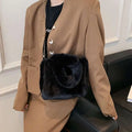 Black faux fur crossbody bag with chain strap featuring soft plush texture and chain plush handbag design elements