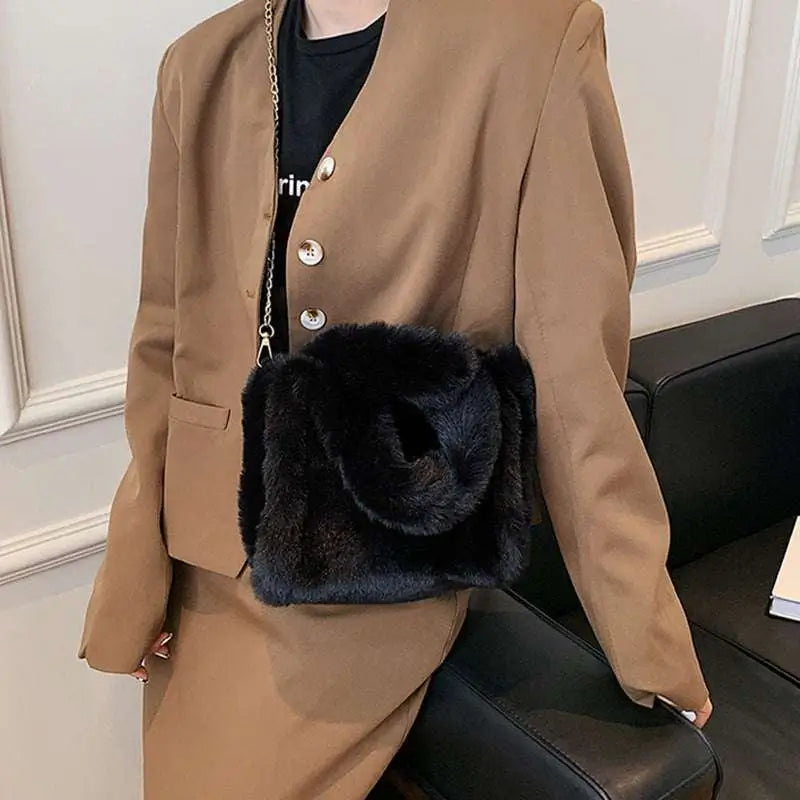 Black faux fur crossbody bag with chain strap featuring soft plush texture and chain plush handbag design elements