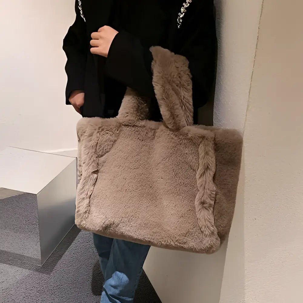 A cozy beige faux fur tote bag with braided handles and sides featuring soft plush texture and chain plush handbag style