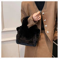 Black faux fur crossbody bag with gold chain strap featuring soft plush texture in a chain plush handbag style