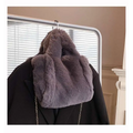 A gray faux fur chain plush handbag with soft plush texture hanging on a coat rack for stylish use
