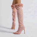 Pink suede knee-high boots with pink faux fur trim and a fine pointed stiletto heel high heel design
