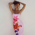 A form-fitting pink floral american style flower strap dress with vibrant magenta orange and purple prints