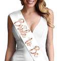 A white satin sash with rose gold foil bride cursive lettering and a diamond-shaped embellishment on popular tulle bridal veil