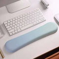 A soft light blue ergonomic wrist rest made of memory foam soft material for wrist health and comfort