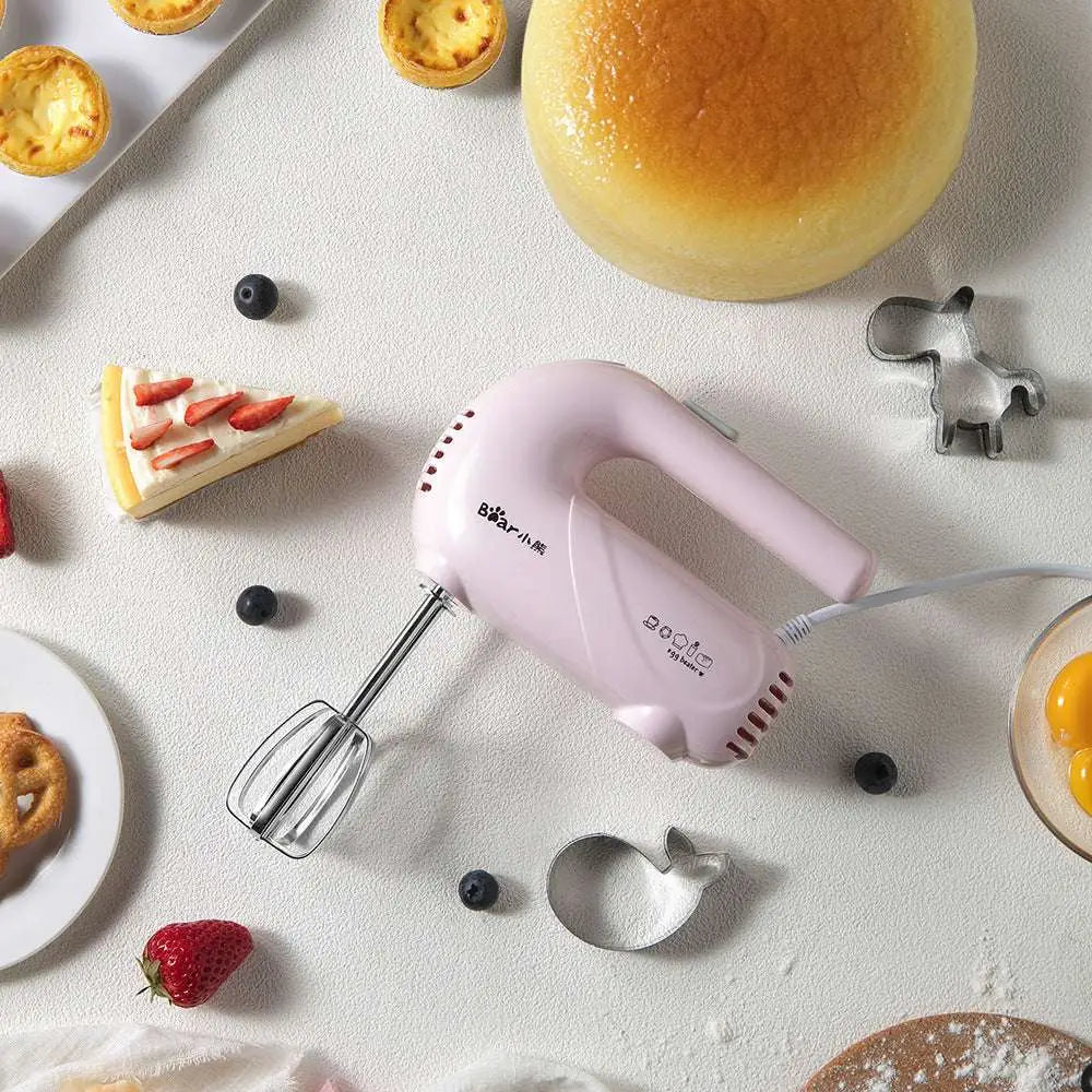 Pastel pink handheld electric whisk with metallic beaters and ergonomic design for luxury women’s fashion kitchens