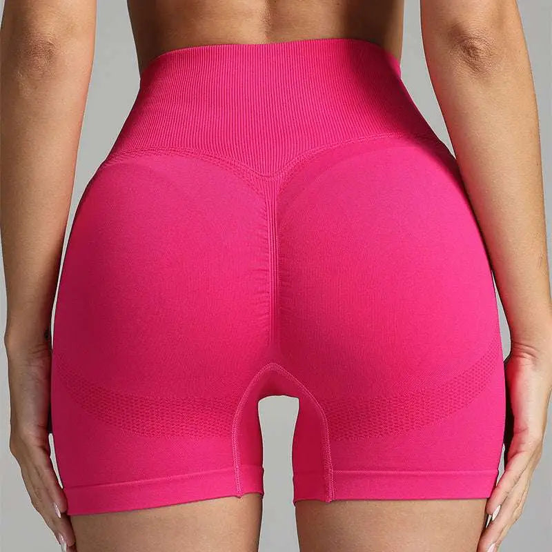 Pink high waist seamless yoga shorts with ribbed waistband, textured design, and breathable mesh panels for women