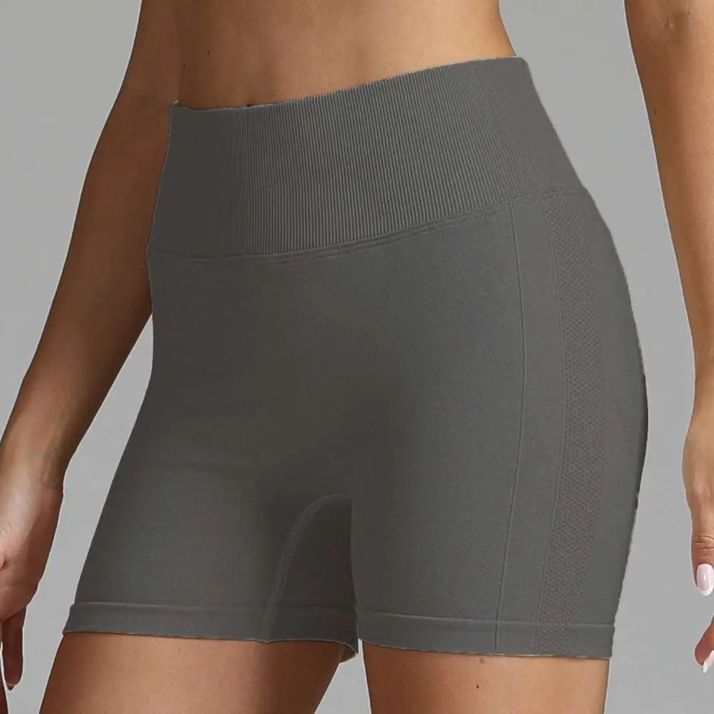 Gray high waist seamless yoga shorts with ribbed waistband and mesh side panels for women fitness wear