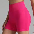 Pink high waist seamless yoga shorts with ribbed waistband and mesh panel for women in bright pink color